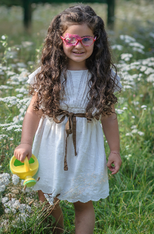 Fille avec cache oculaire chevaux et arrosoir à la main